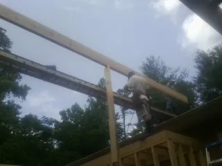 Carpenter setting a ridge beam over a new addition frame — Ice Dam Removal by Roofing Brothers in Mayville