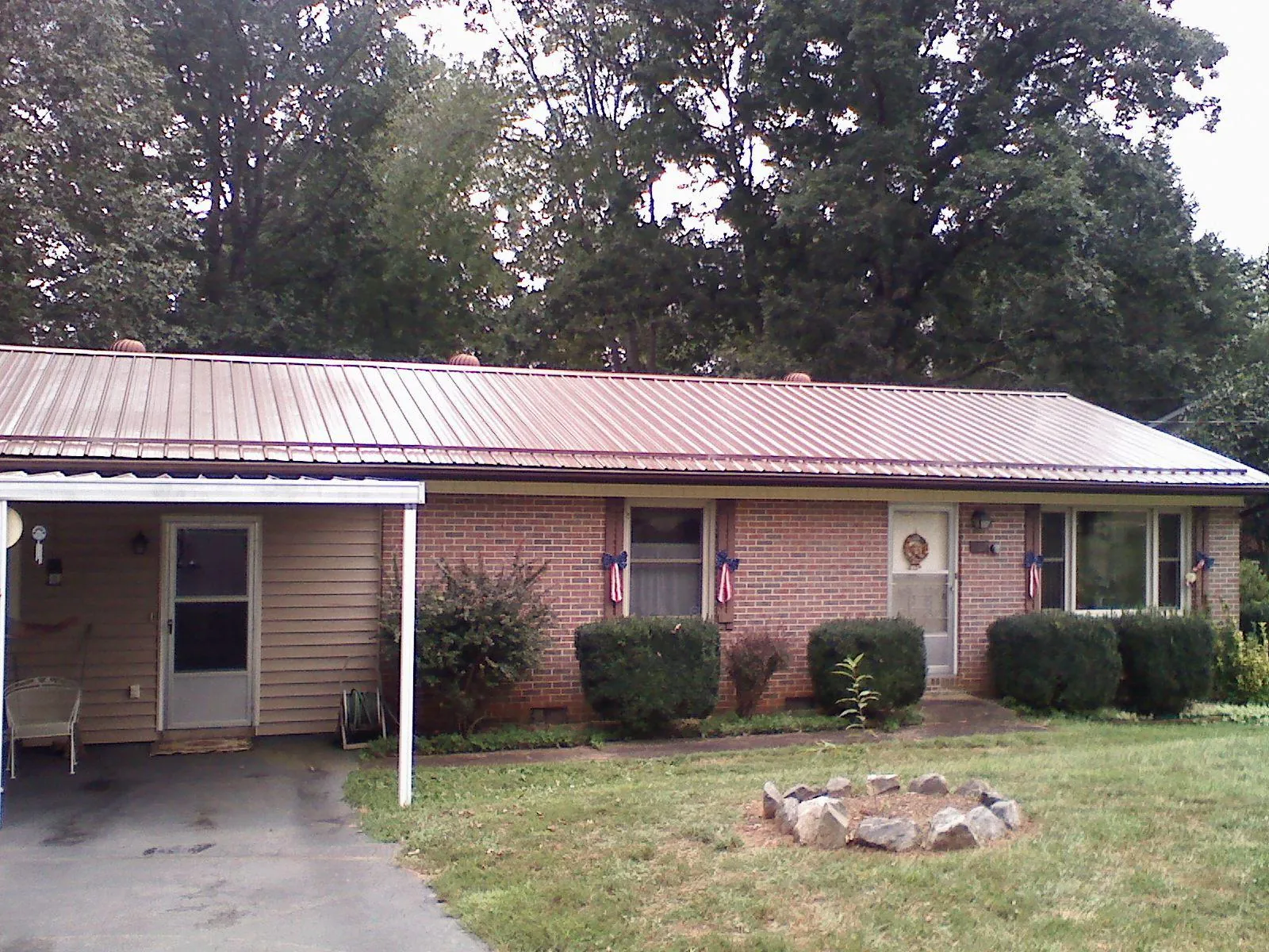 Bronze metal roof and carport on a brick ranch home — Roof Repair work by our crew in Mayville
